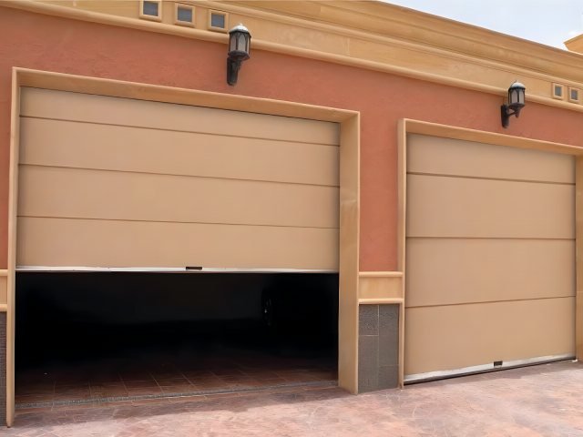 باب كراج كهربائي مقطعي بجوار باب رول في موقع التنفيذ في الرياض